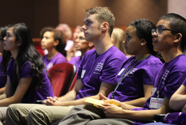 undergraduate students wearing purple shirts sitting in an audience