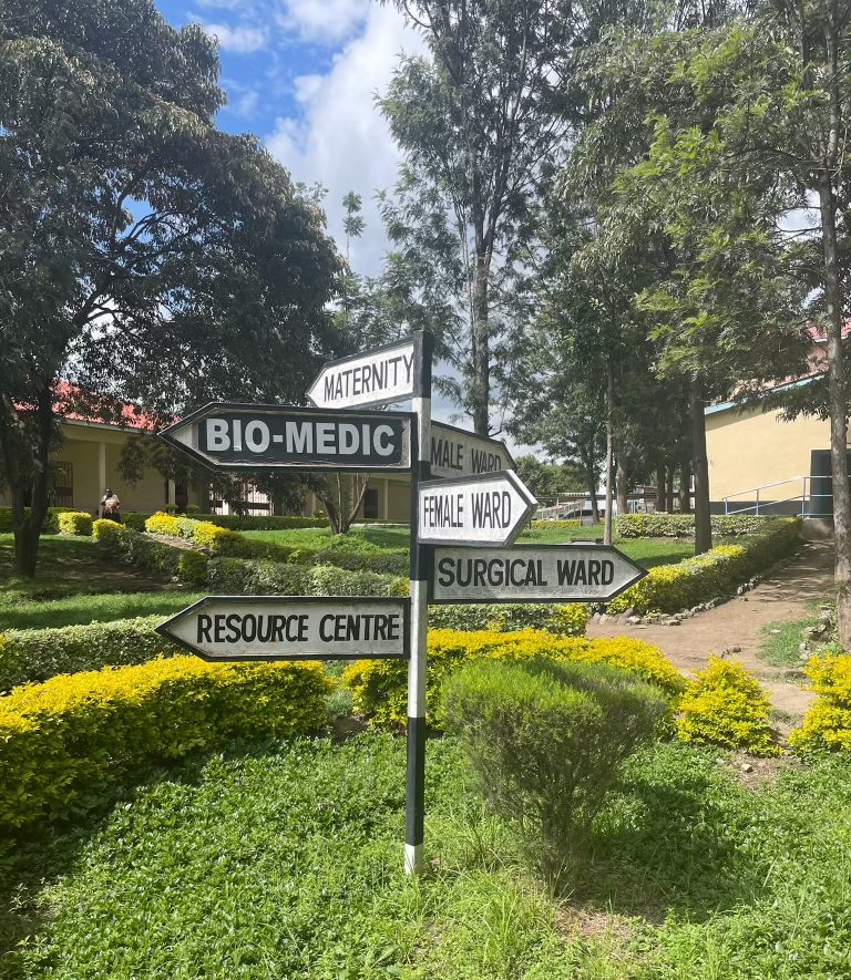 Outdoor sign pointing to different clinical areas at Naivasha Hospital.