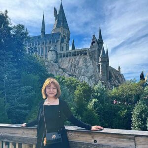 Dr. Jingyi Chen standing on a bridge in front of a castle.
