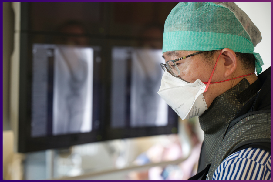 Dr. Jiang Wu, focused on a task in a clinical space at UW Medicine