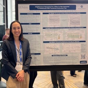 Fran Querdasi poses in front of her research poster at a conference.