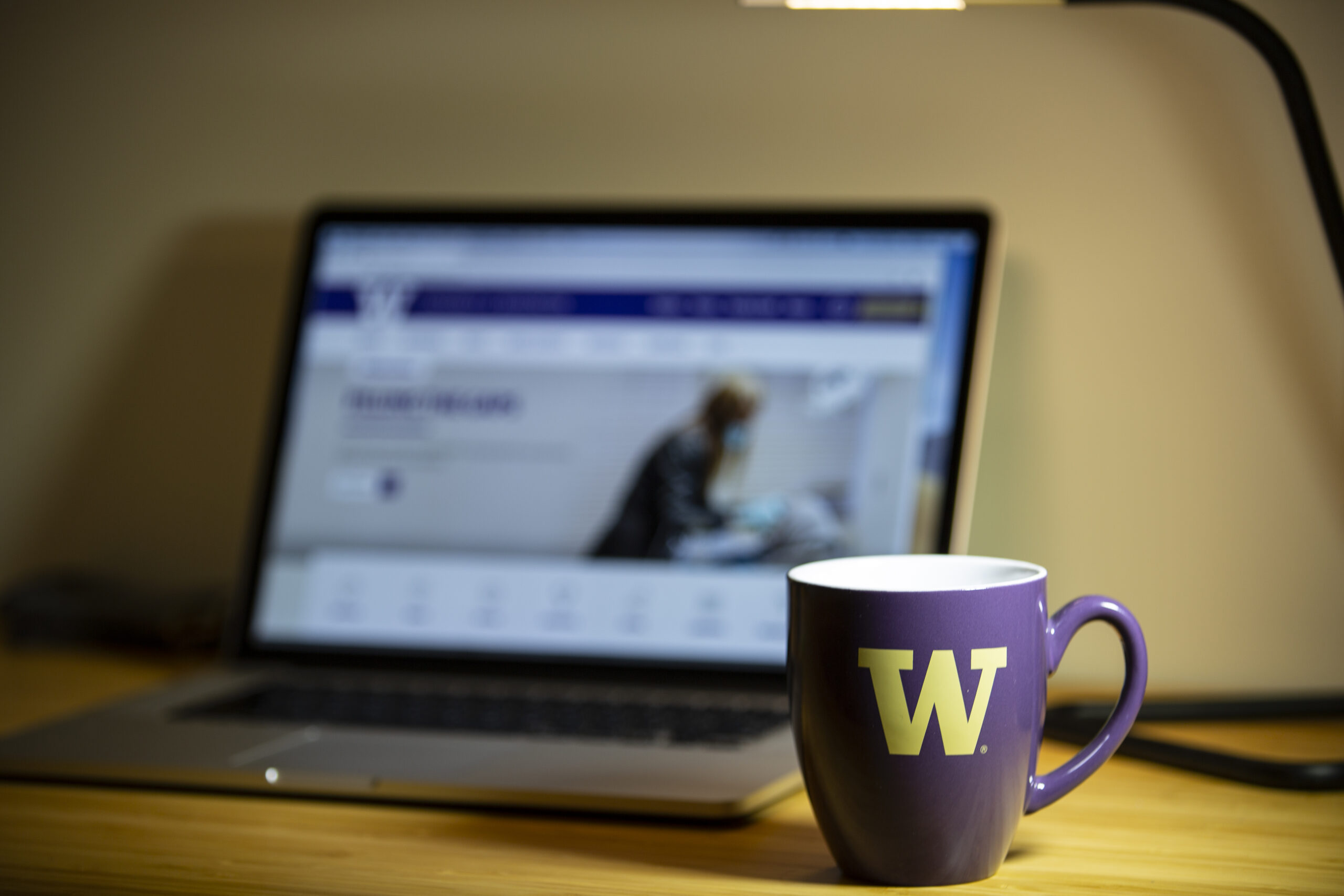 A purple coffee mug branded with the University 